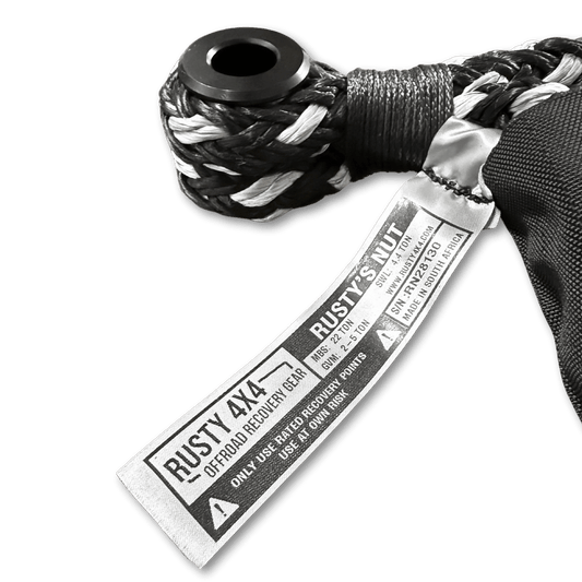 Tow hitch recovery soft shackle with black and white braid, metal loop, and stitched tag