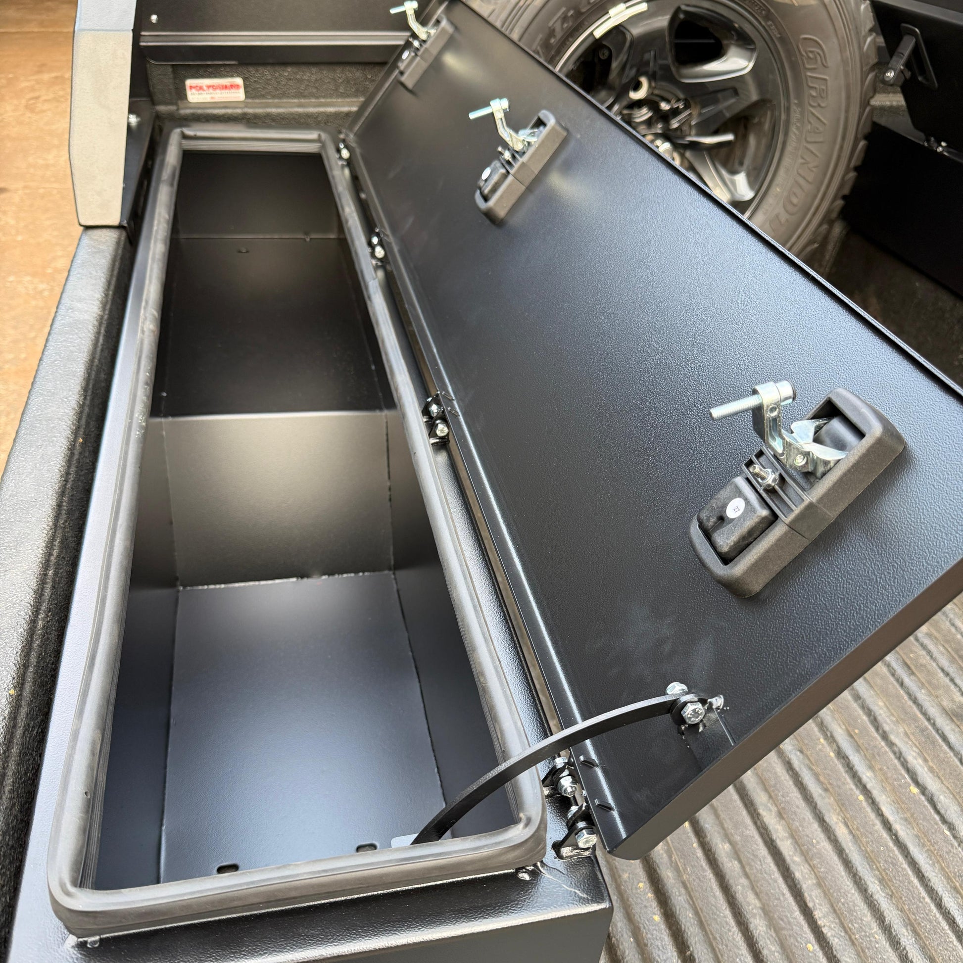 Metal tool box with open lid on a truck bed