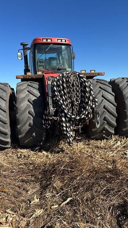 Black-and-white braided kinetic recovery rope coiled on tractor front